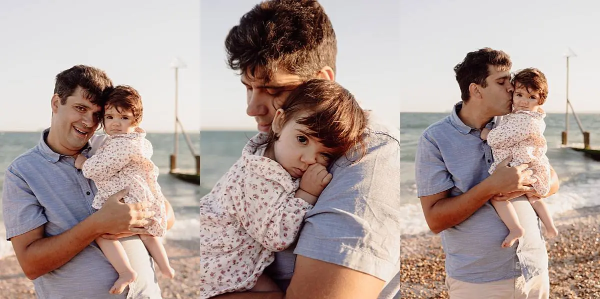 Family enjoying a sunset beach photo shoot on Hayling Island with their two dogs and one-year-old daughter