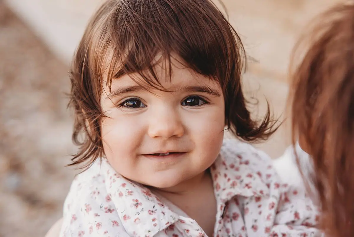Family enjoying a sunset beach photo shoot on Hayling Island with their two dogs and one-year-old daughter
