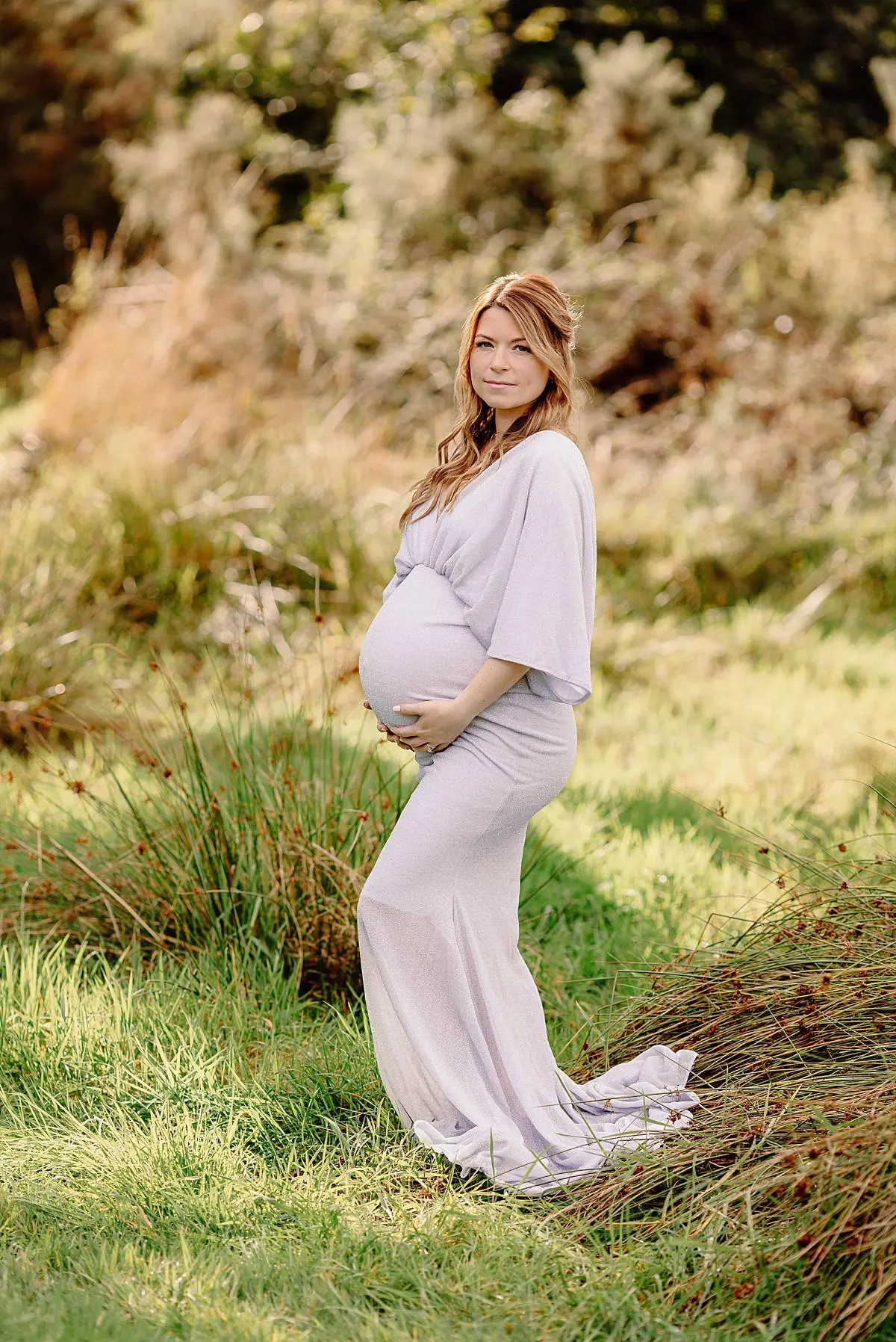 expecting mum holding bump during an outdoors pregnancy session at the Fareham area, professional photoshoot