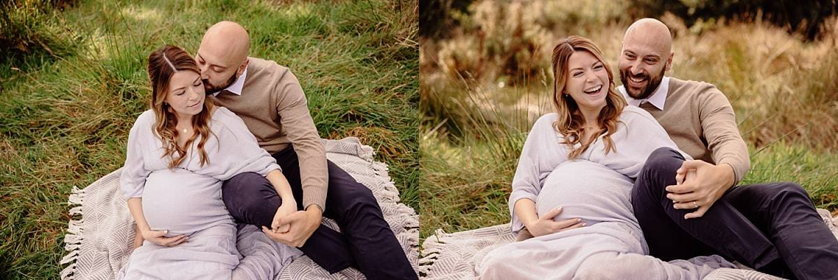 Outdoor maternity photoshoot with a couple standing under a tree, surrounded by autumn leaves