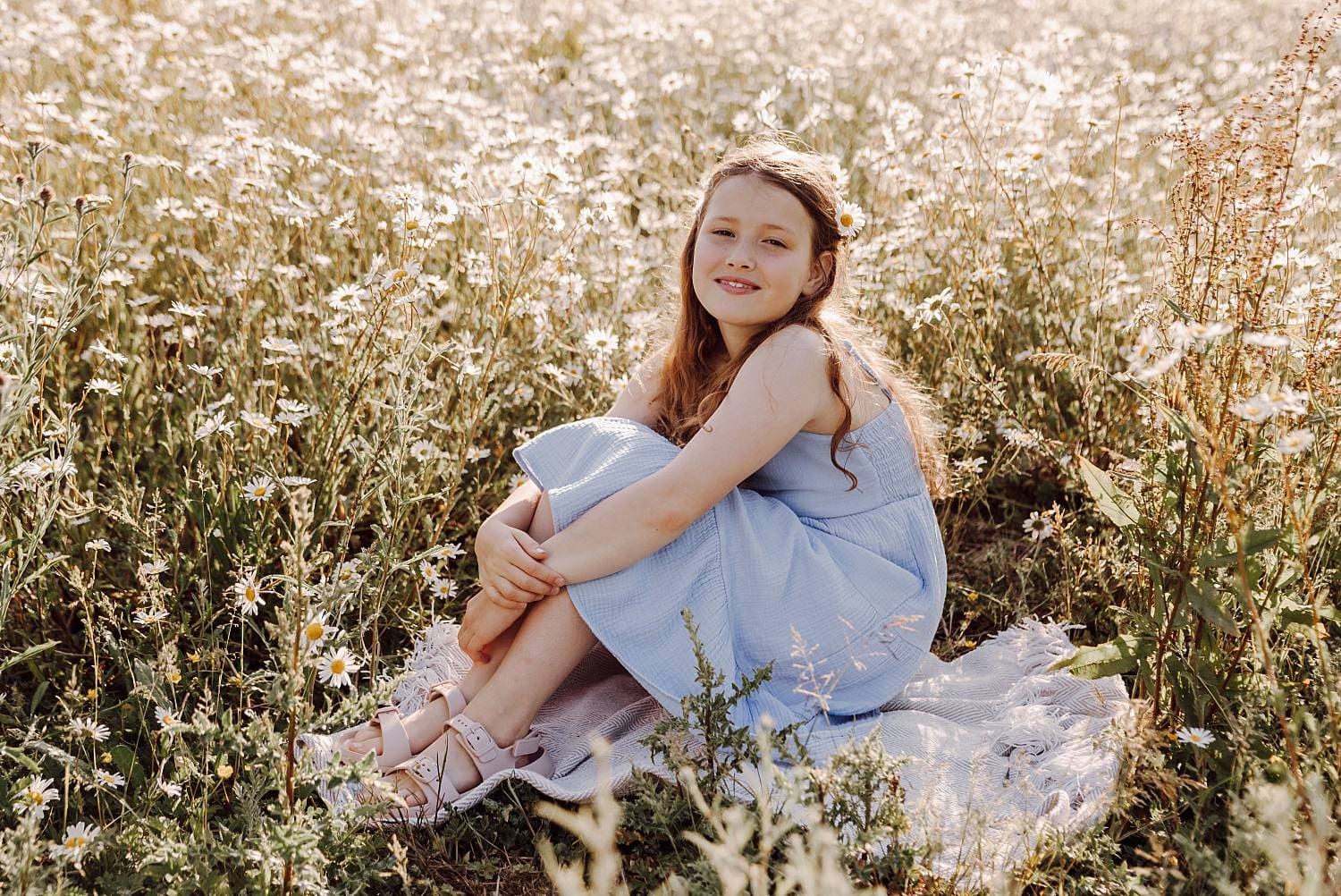 Natural family portrait in daisy field with soft summer light