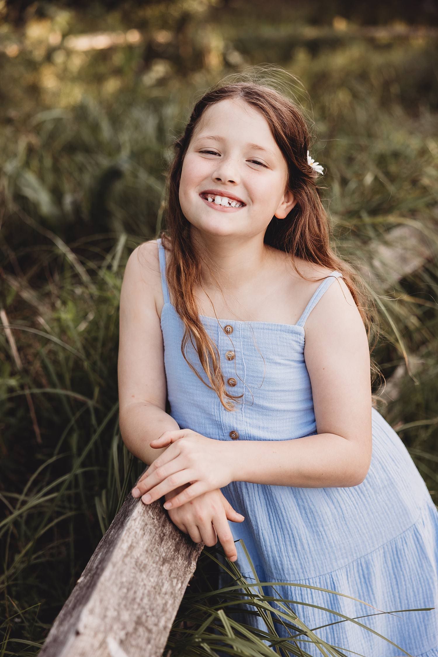Natural family portrait in daisy field with soft summer light
