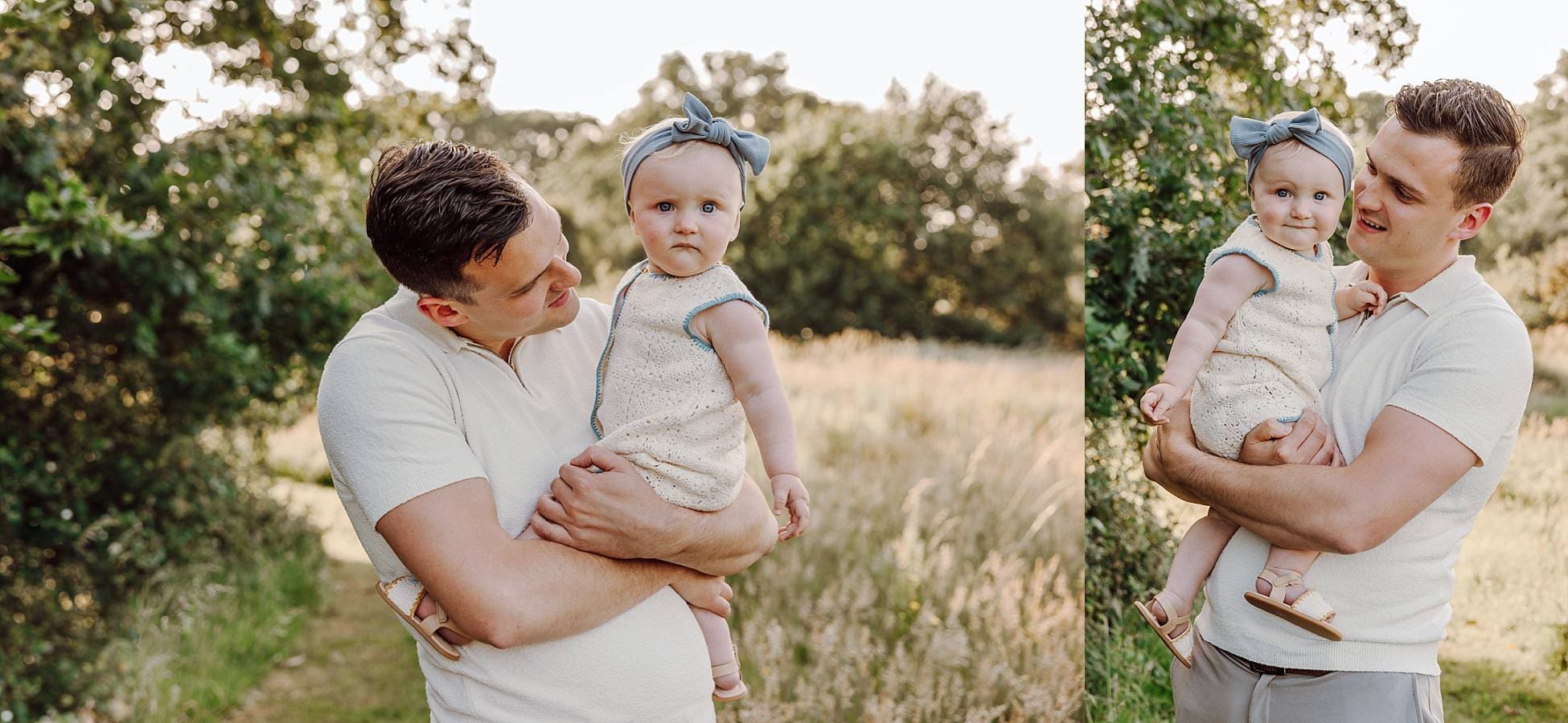 Toddler girl smiling while being held by dad in meadow