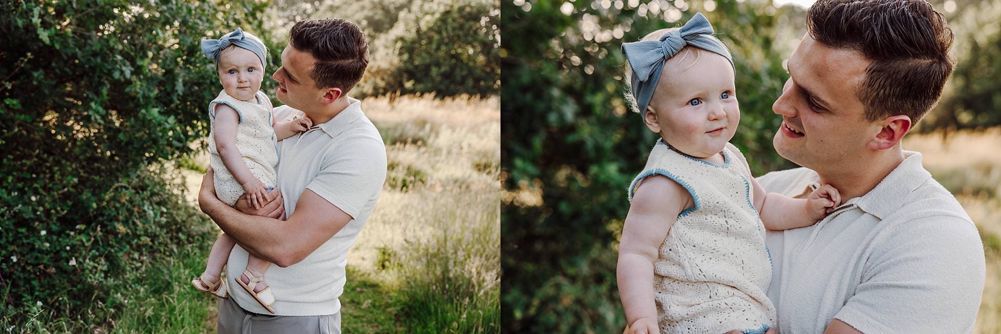 Toddler girl smiling while being held by dad in meadow