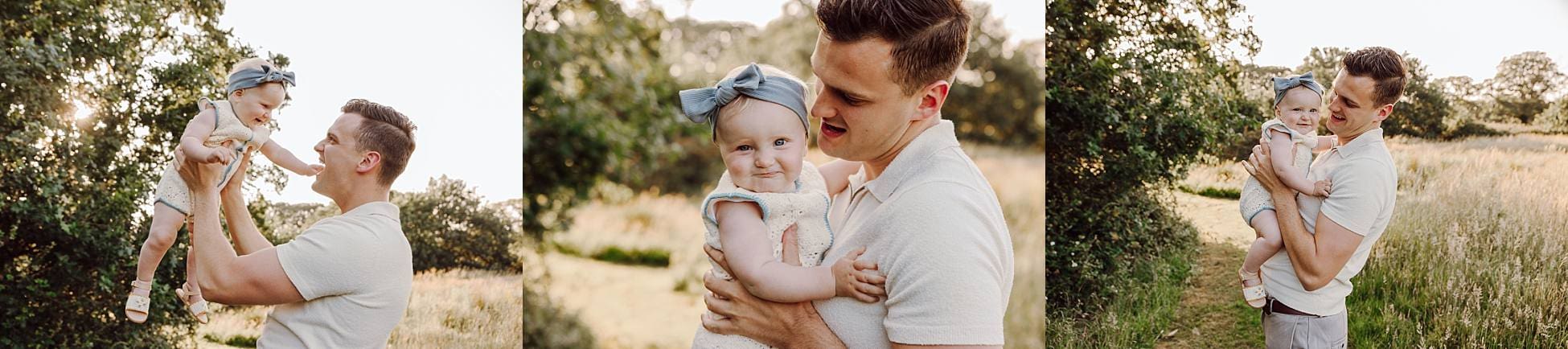 Dad kissing baby girl while mum looks on in meadow