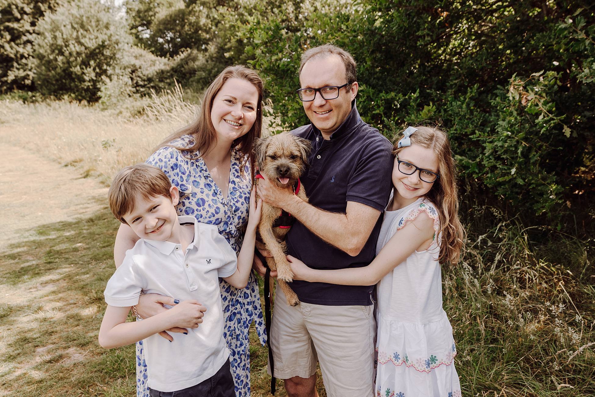 Family group portrait with dog in Hampshire meadow