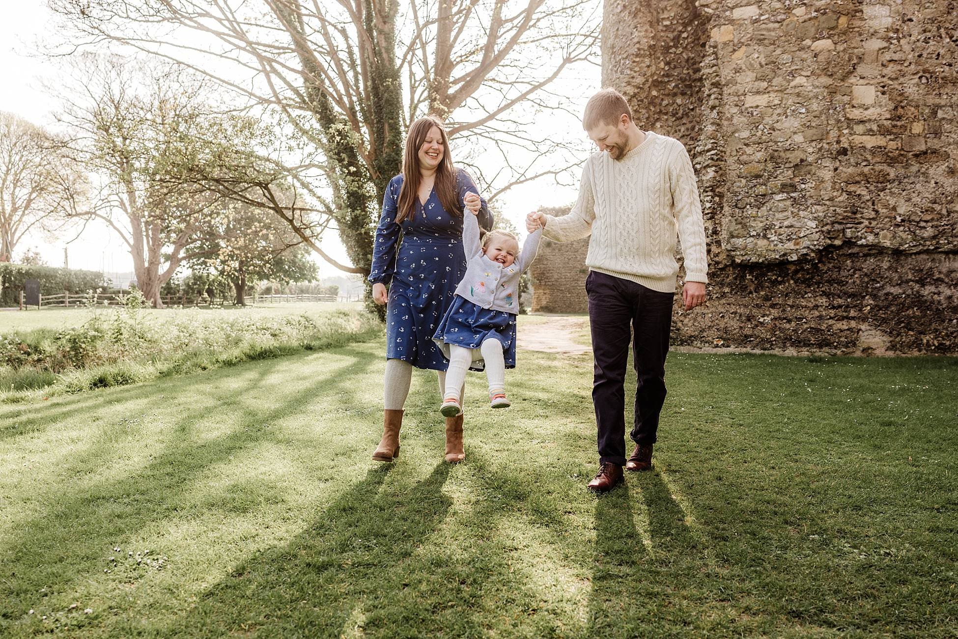 Family portrait by wooden fence at Portchester Castle grounds