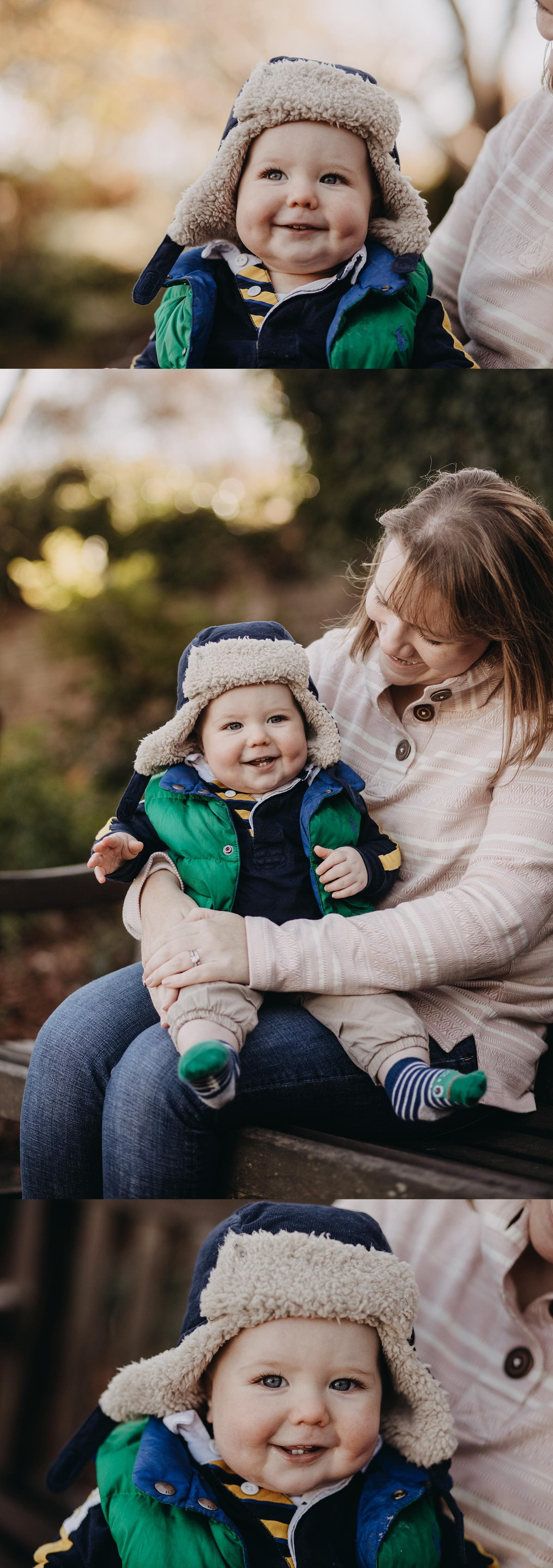 Smiling baby in a winter hat sitting on mother’s lap during a Southsea family photoshoot