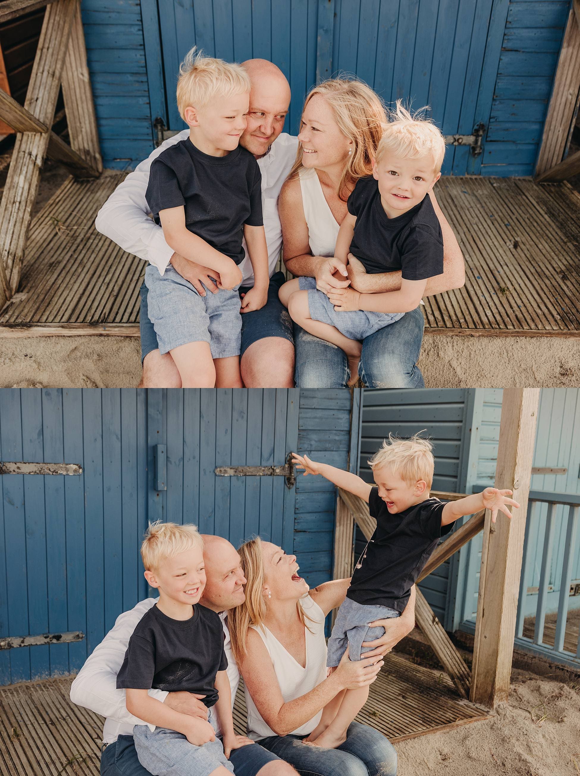 Family sitting on wooden steps by a blue beach hut, laughing together