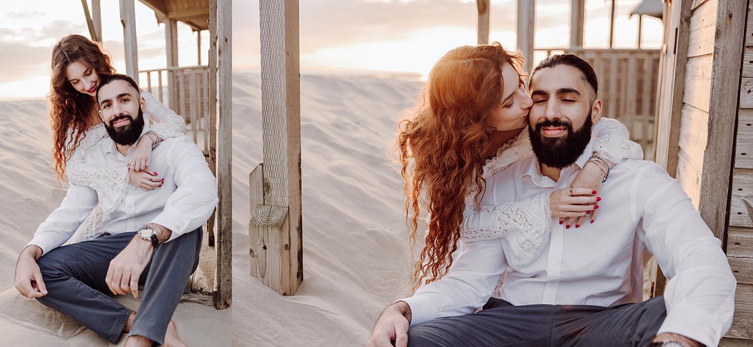 Romantic West Wittering engagement photo with bride embracing groom at golden hour on sandy dunes.