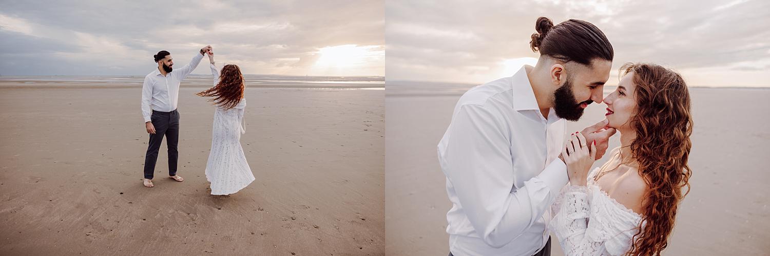 Couple walking hand in hand along shoreline at West Wittering during golden hour engagement photography.