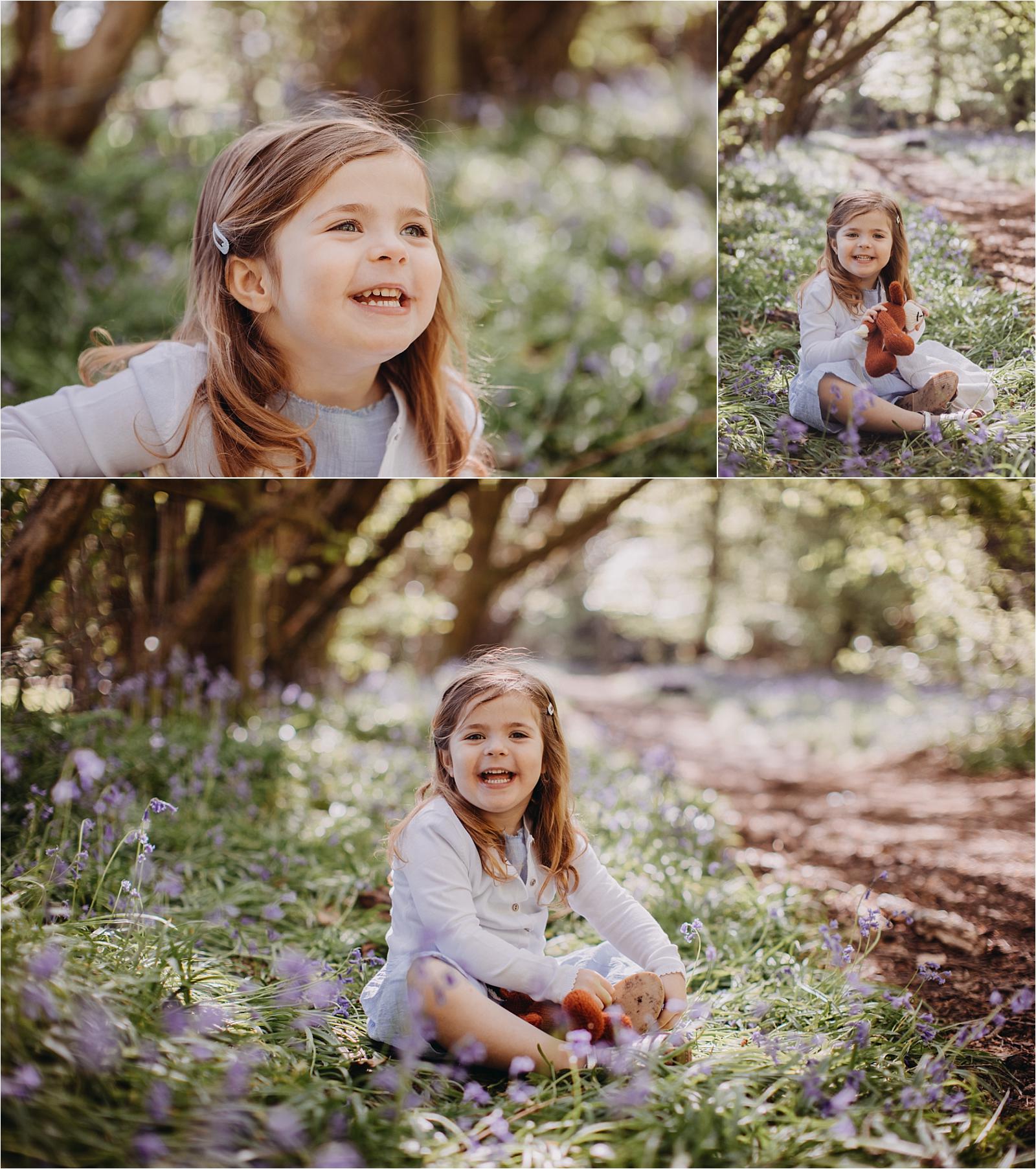 Young girl sitting in bluebell woodland in Hampshire, natural children photography during spring mini session with soft light