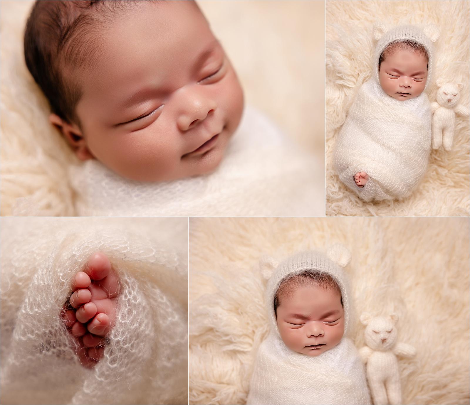 Newborn baby smiling in sleep, wrapped in cream with a knitted bonnet and teddy — professional newborn home photography in Hampshire