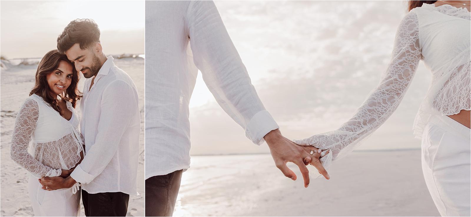 Close-up of an expectant couple holding hands by the sea during their maternity photoshoot at West Wittering